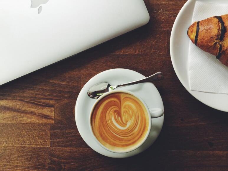 A cup of coffee and pastry on plate